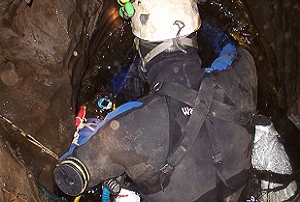 A British cave diver prepares to dive in a constricted sump pool
