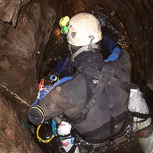 A British cave diver prepares to dive in a constricted sump pool
